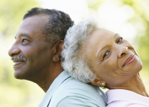 Older couple leaning on each other outside