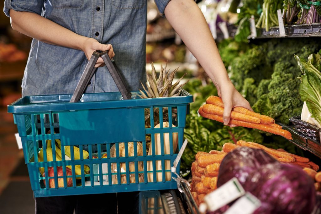 Woman shopping at a grocery store with a basket