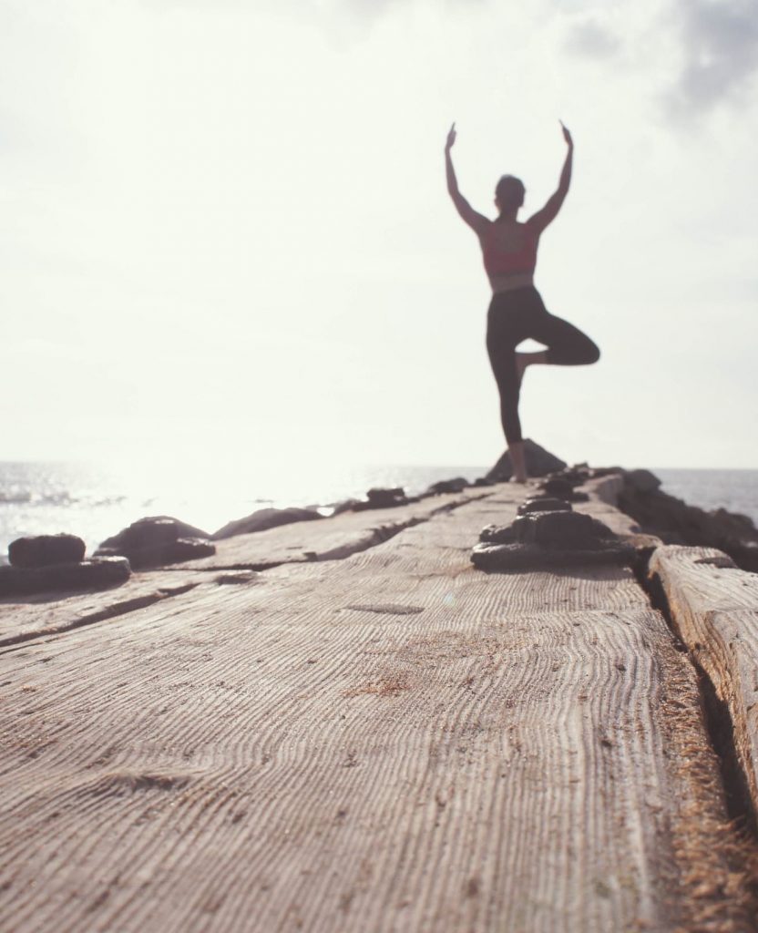 Man doing yoga by the ocean