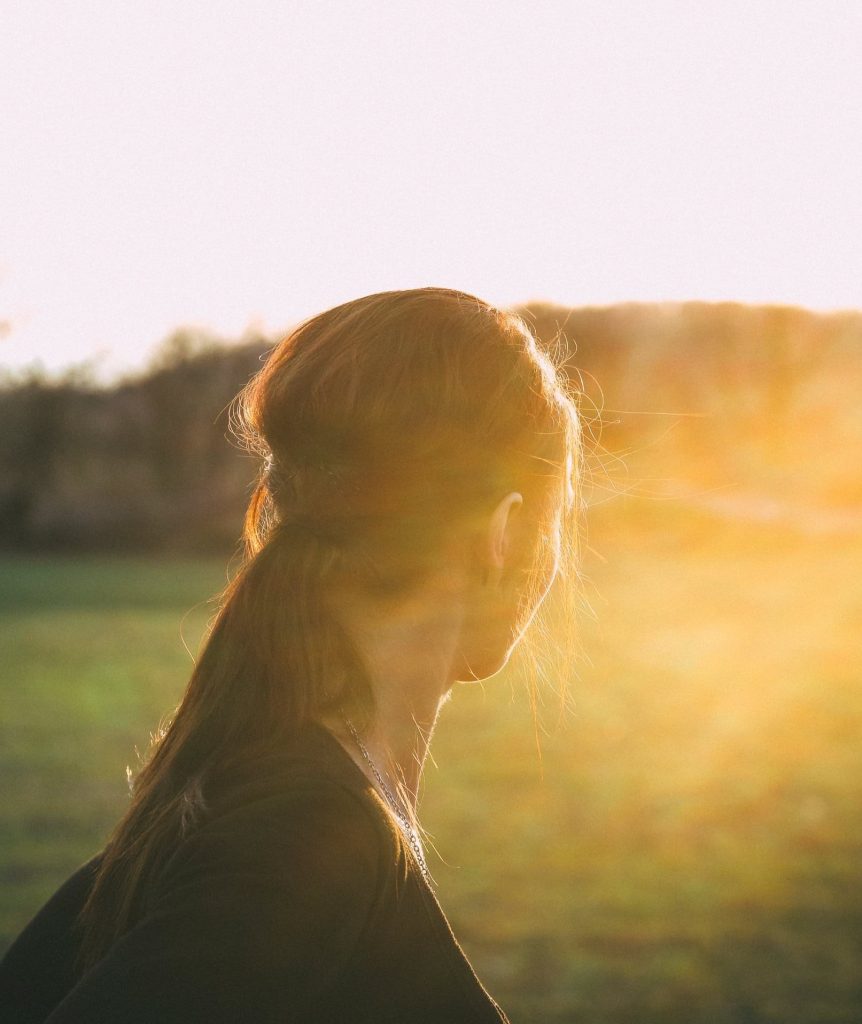 Woman looking out at a sunny landscape